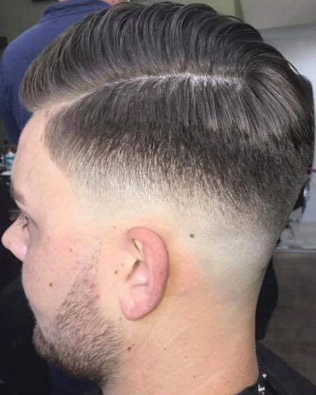 Klant met een strakke fade en een scheiding, van opzij