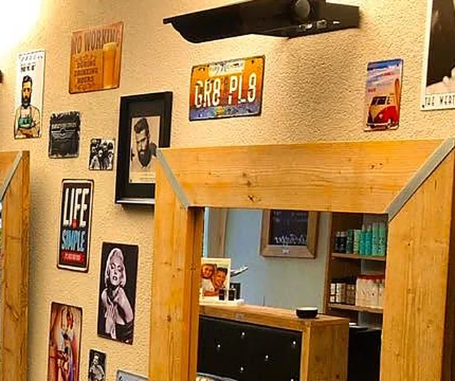 Spiegel in steigerhout met oude blikken borden en ingelijste posters erboven